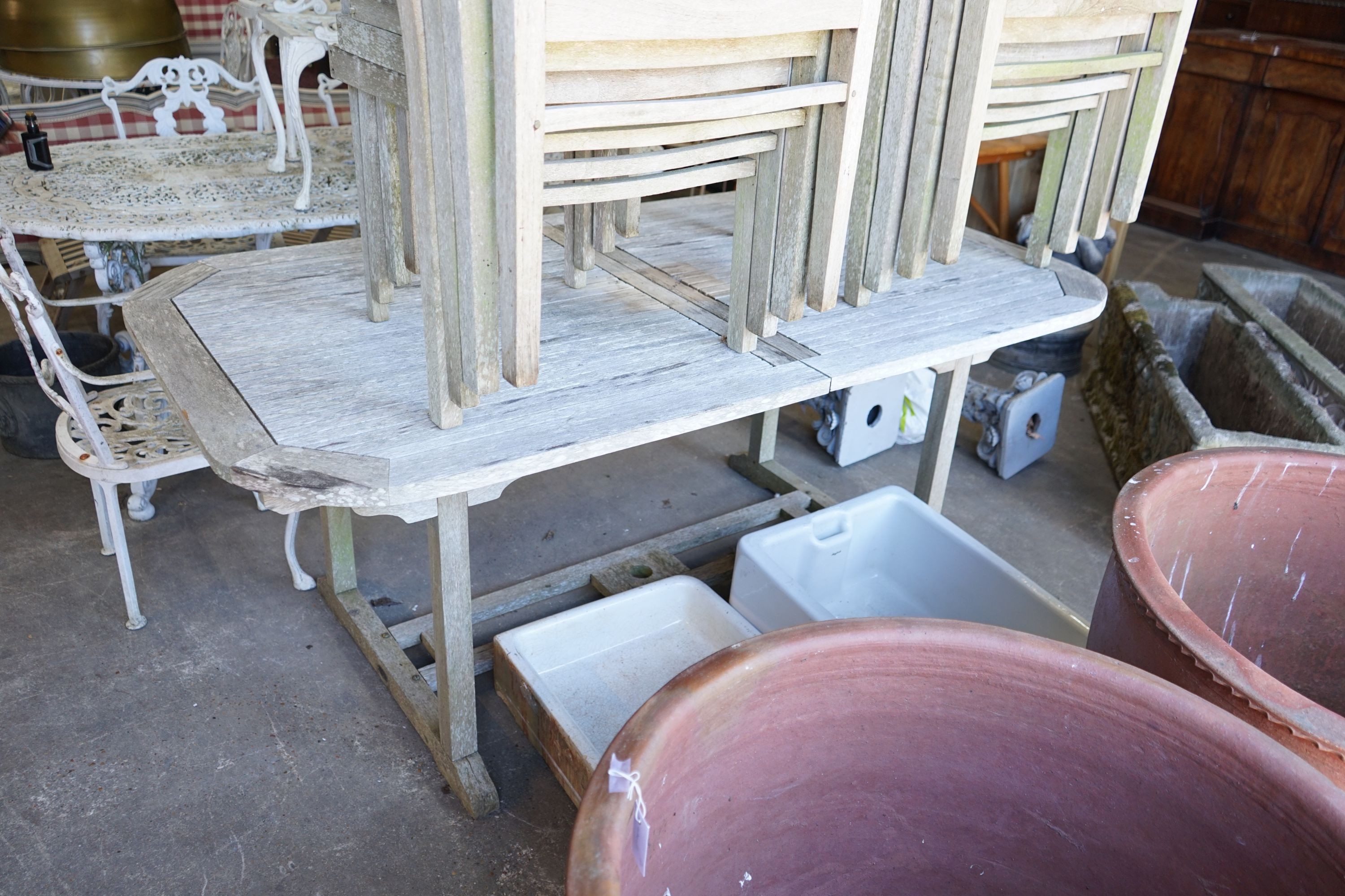 A rectangular weathered teak extending garden table, 250cm extended, width 100cm, height 74cm together with eight matching elbow chairs